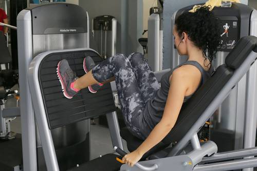 Frau beim Gerätetraining in einem Fitnessstudio
