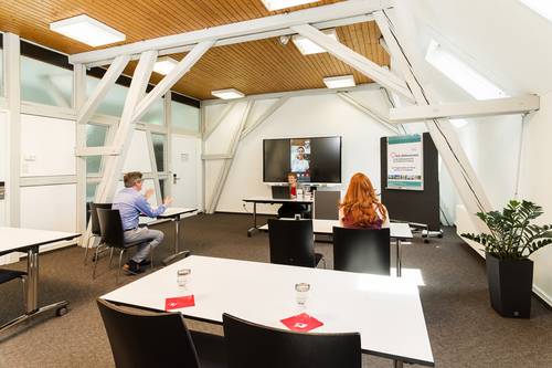 Ansicht einer hybriden Konferenz mit Personen im Bildungshaus St. Bernhard